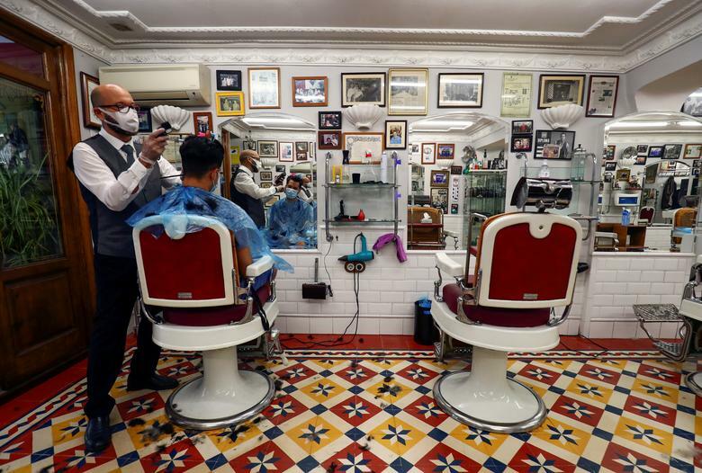 Một hiệu cắt tóc tại Madrid (Tây Ban Nha) trong ngày đầu tiên mở cửa trở lại. Ảnh: Reuters